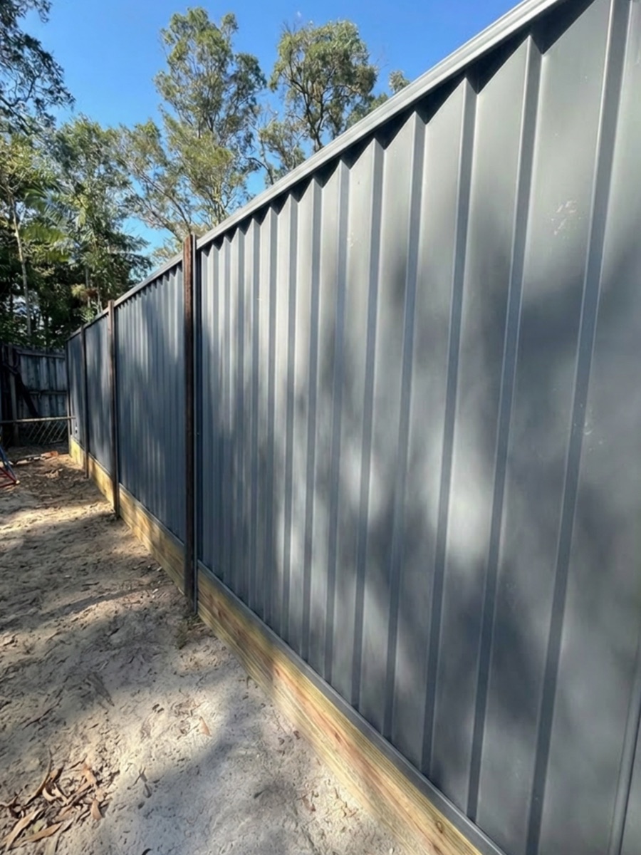 Feature fence with sanded timber posts and Colorbond panels by CoasTrade