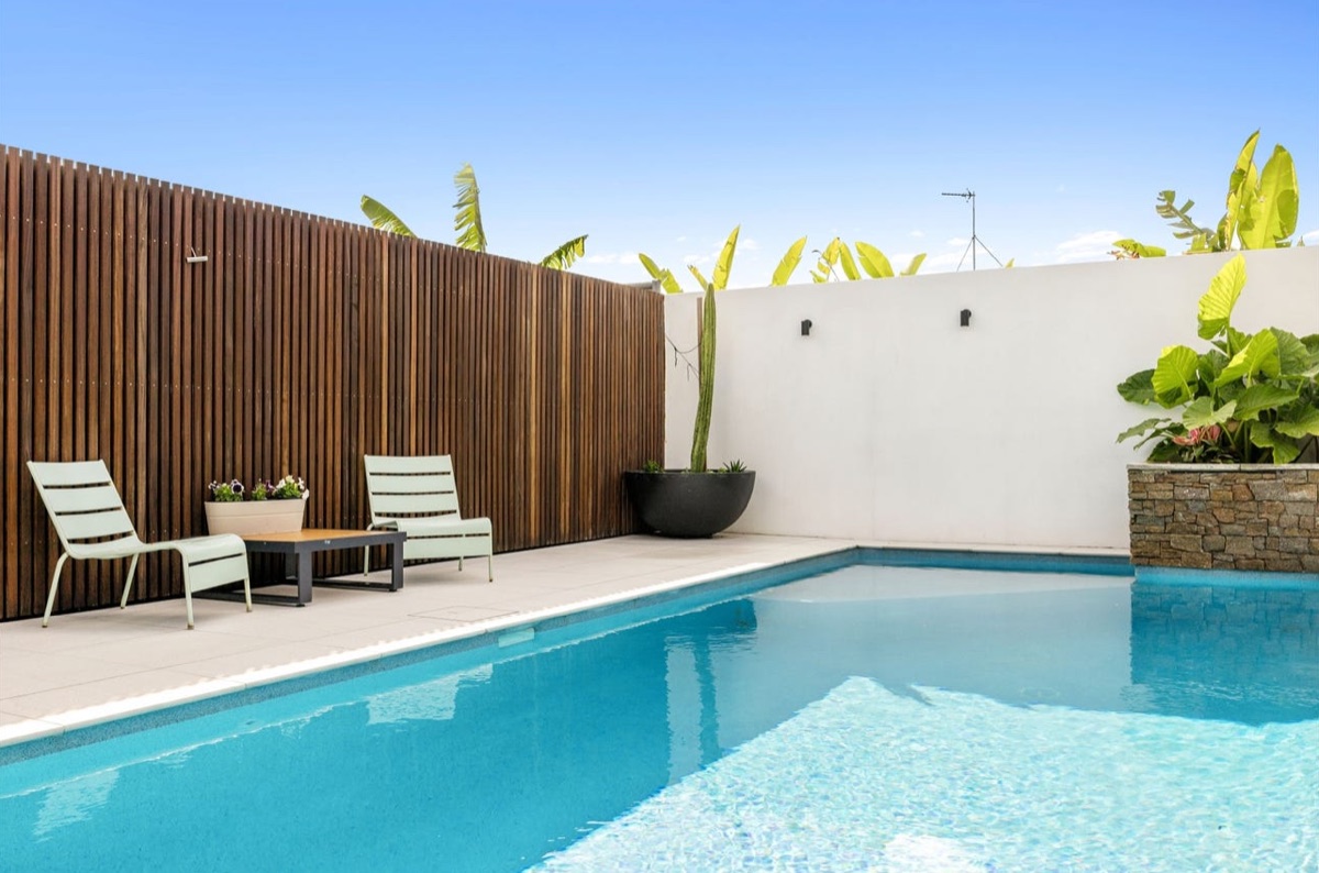 Merbau batten feature screen by a pool, installed by CoasTrade